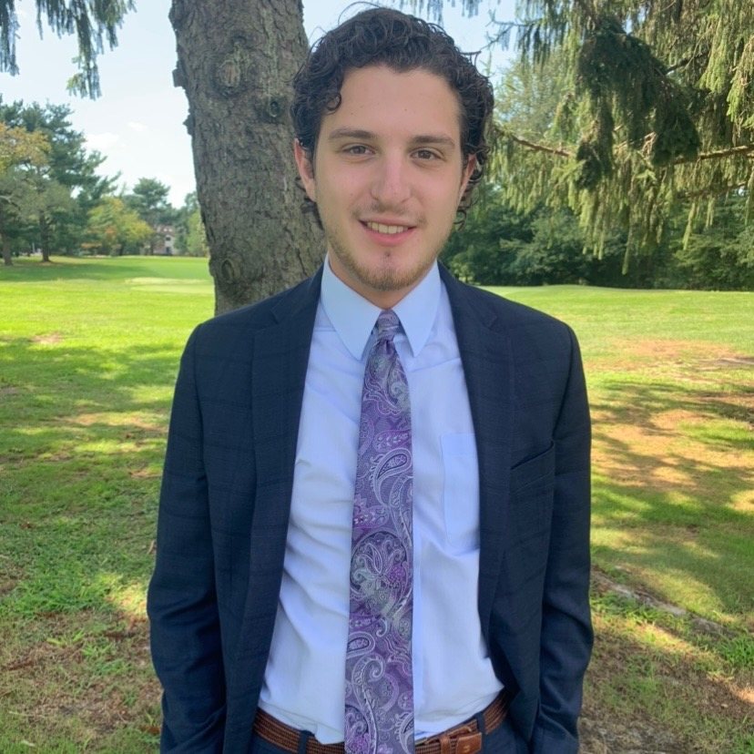 Jeremy Blaker in a suit, standing outdoors